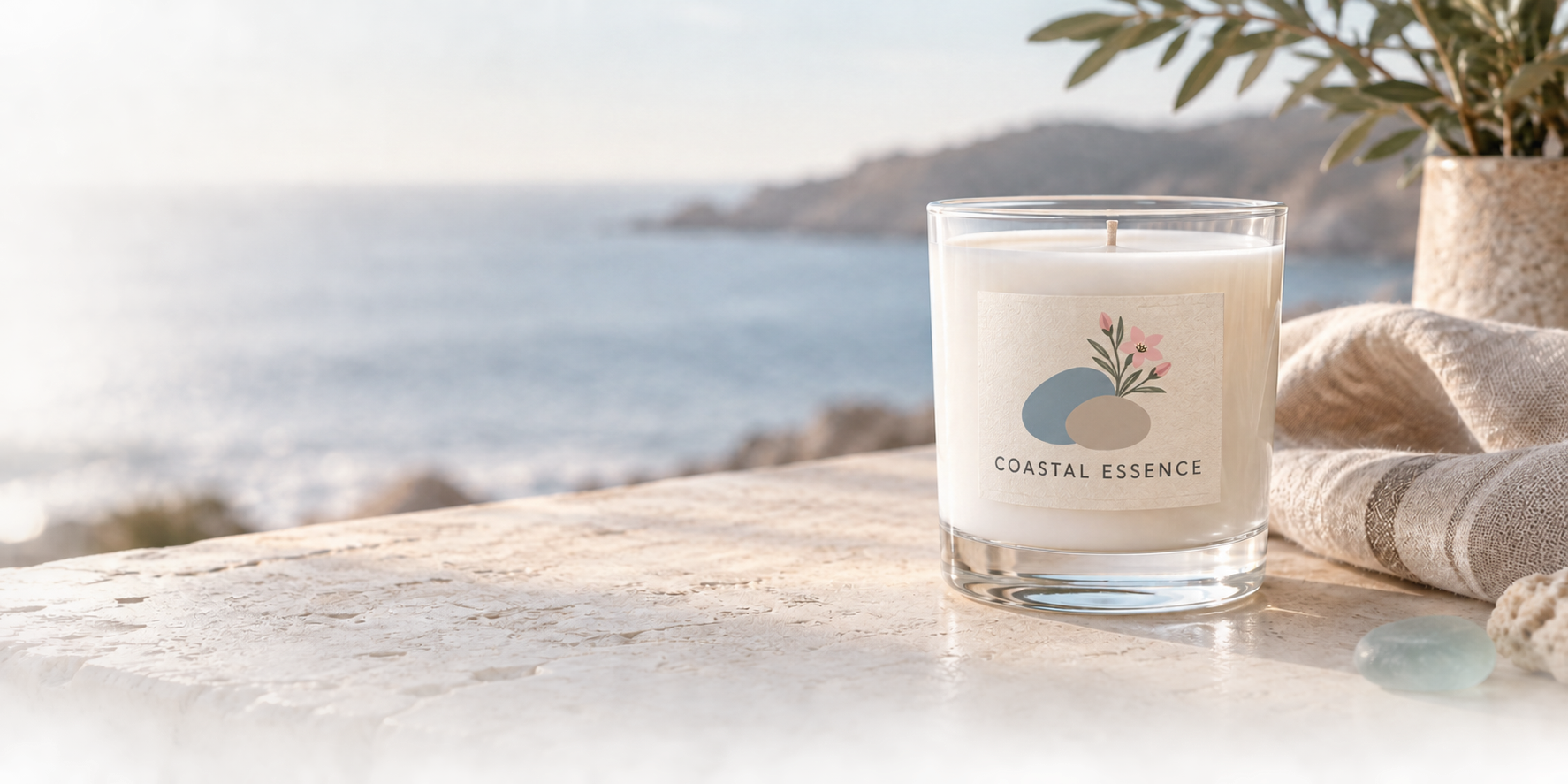 A Coastal Essence candle styled beside the coast